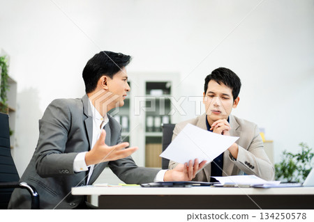 Frustrated manager scolds employee in office over financial error. Concept of workplace stress, reporting issues, conflict Frustrated manager scolds employee in office over financial error. Concept of workplace stress, reporting issues, conflict 134250578