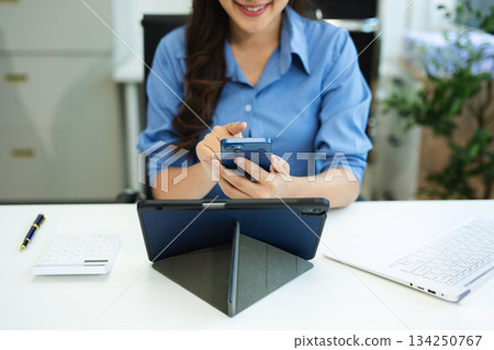 Business woman sitting front tablet ,laptop computer with financial graphs and statistics on monitor. Business woman sitting front tablet ,laptop computer with financial graphs and statistics on monitor. 134250767