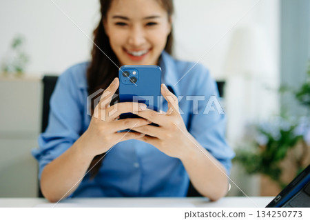 Business woman using smartphone and working on laptop computer  Woman freelancer online working at office 134250773