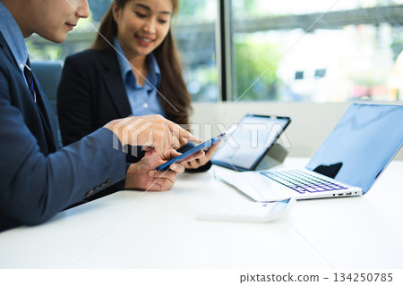 Businessman hand using laptop and tablet with social network diagram and two colleagues discussing data Businessman hand using laptop and tablet with social network diagram and two colleagues discussing data 134250785