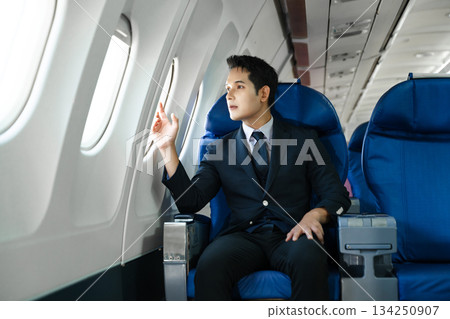 Young Asian executive excels in first class, multitasking with digital tablet, laptop and smartphone. Travel in style, work with grace. Young Asian executive excels in first class, multitasking with digital tablet, laptop and smartphone. Travel in style, work with grace. 134250907