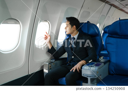 Young Asian executive excels in first class, multitasking with digital tablet, laptop and smartphone. Travel in style, work with grace. Young Asian executive excels in first class, multitasking with digital tablet, laptop and smartphone. Travel in style, work with grace. 134250908