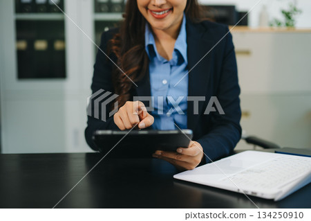 Businesswoman utilizing smartphone and tablet technology. Perfect for corporate, technology, and modern business visuals 134250910
