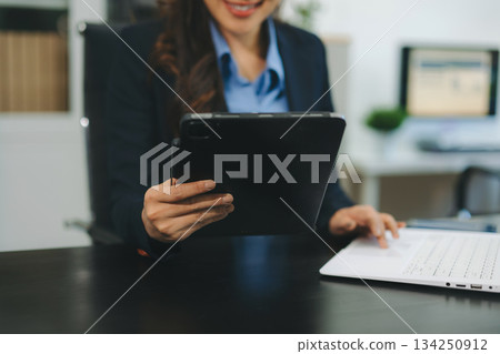 Businesswoman utilizing smartphone and tablet technology. Perfect for corporate, technology, and modern business visuals 134250912
