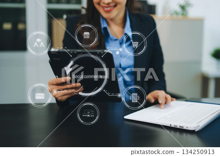 Female hand using smart phone and tablet with social commerce icon on virtual screen e-commerce and social media 134250913