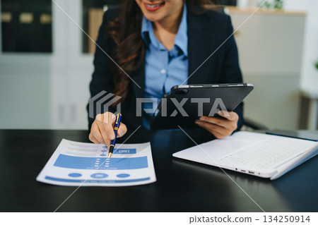 Businesswoman utilizing smartphone and tablet technology. Perfect for corporate, technology, and modern business visuals 134250914