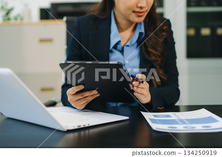 Businesswoman utilizing smartphone and tablet technology. Perfect for corporate, technology, and modern business visuals 134250919