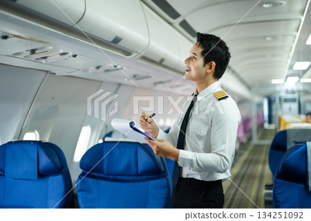 Professional airline pilot inspecting airplane cabin during safety check, perfect for aviation, travel, and airline safety concept stock photography 134251092