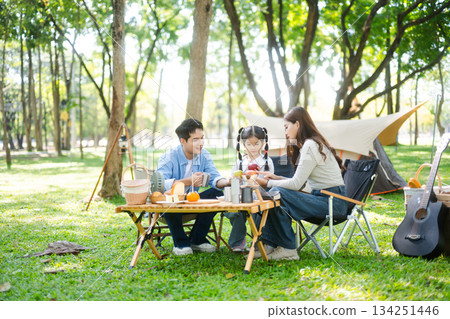 Happy parents and daughter Bakery and Bread Fruit enjoy in a sunny garden. A joyful summer picnic full of love, food for family, outdoor Happy parents and daughter Bakery and Bread Fruit enjoy in a sunny garden. A joyful summer picnic full of love, food for family, outdoor 134251446