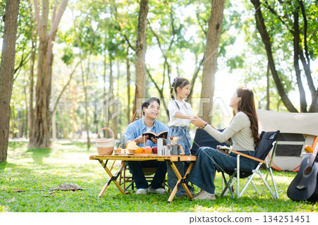 Happy parents and daughter Bakery and Bread Fruit enjoy  in a sunny garden. A joyful summer picnic full of love, food for family, outdoor 134251451