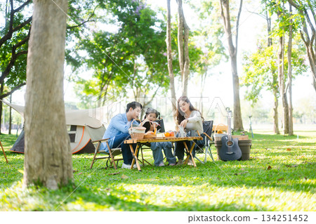 Happy parents and daughter Bakery and Bread Fruit enjoy in a sunny garden. A joyful summer picnic full of love, food for family, outdoor Happy parents and daughter Bakery and Bread Fruit enjoy in a sunny garden. A joyful summer picnic full of love, food for family, outdoor 134251452