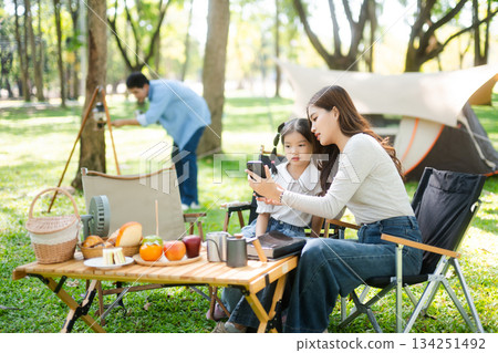 Asian couple enjoys a peaceful camping morning with coffee, breakfast, music, and devices in nature with love Asian couple enjoys a peaceful camping morning with coffee, breakfast, music, and devices in nature with love 134251492