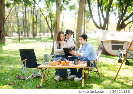 Asian couple enjoys a peaceful camping morning with coffee, breakfast, music, and devices in nature with love Asian couple enjoys a peaceful camping morning with coffee, breakfast, music, and devices in nature with love 134251518
