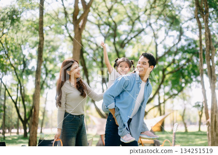 Happy parents and daughter Bakery and Bread Fruit enjoy  in a sunny garden. A joyful summer picnic full of love, food for family 134251519