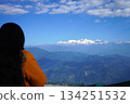 Young woman looking at snowcapped Himalayan mountain peaks from a scenic viewpoint 134251532