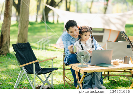 Happy parents and daughter Bakery and Bread Fruit enjoy in a sunny garden. A joyful summer picnic full of love Happy parents and daughter Bakery and Bread Fruit enjoy in a sunny garden. A joyful summer picnic full of love 134251656