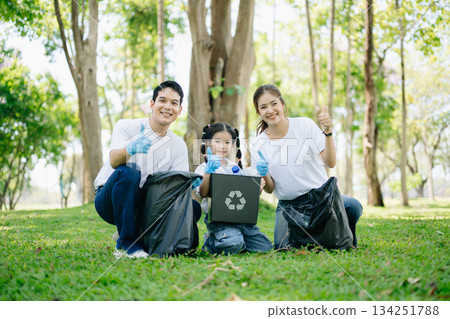 Asian parents and child collect bottles at the park, sharing love, teamwork, and care. A green lifestyle moment promoting recycling, unity Asian parents and child collect bottles at the park, sharing love, teamwork, and care. A green lifestyle moment promoting recycling, unity 134251788