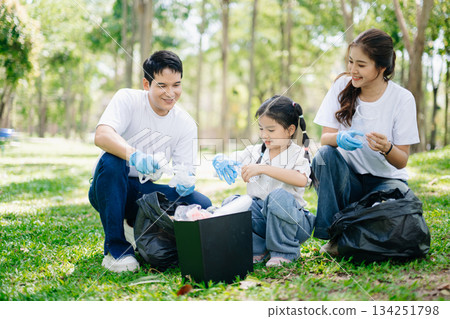 Asian parents and child collect bottles at the park, sharing love, teamwork, and care. A green lifestyle moment promoting recycling, unity Asian parents and child collect bottles at the park, sharing love, teamwork, and care. A green lifestyle moment promoting recycling, unity 134251798