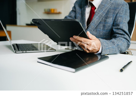 Businessman hand using smart phone laptop and tablet with social network diagram on desk as concep Businessman hand using smart phone laptop and tablet with social network diagram on desk as concep 134251857