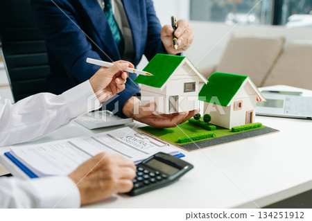 balancing the property sector The real estate agent is explaining the house style to see the house design balancing the property sector The real estate agent is explaining the house style to see the house design 134251912