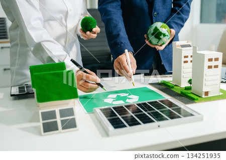 Engineers discuss solar panels and turbines in office, working on clean energy design, sustainable power 134251935