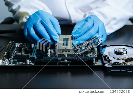 The technician is putting the CPU on the socket of the computer motherboard. electronic engineering electronic 134252028