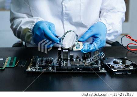 The technician is putting the CPU on the socket of the computer motherboard. electronic engineering electronic 134252033