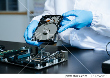 Hard disk drive on the technician's desk and a computer motherboard as a component. the concept of data, hardware Hard disk drive on the technician's desk and a computer motherboard as a component. the concept of data, hardware 134252038