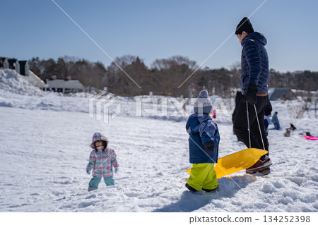 Parent and child playing in the snow Parent and child playing in the snow 134252398
