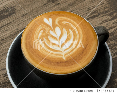 Hot coffee, a hot latte in a mug on a wooden table. 134253384