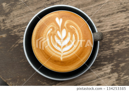 Hot coffee, a hot latte in a mug on a wooden table. Hot coffee, a hot latte in a mug on a wooden table. 134253385