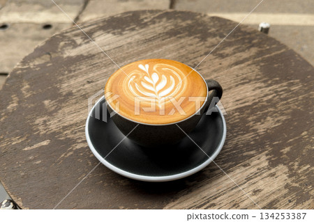 Hot coffee, a hot latte in a mug on a wooden table. 134253387