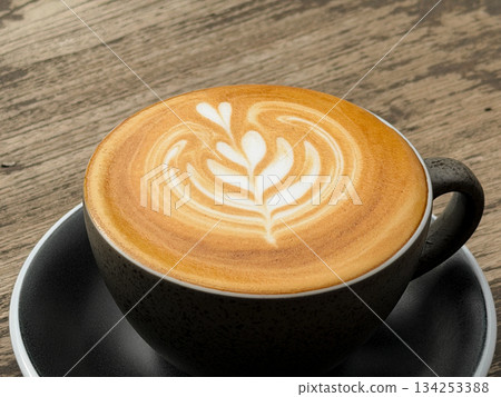 Hot coffee, a hot latte in a mug on a wooden table. 134253388