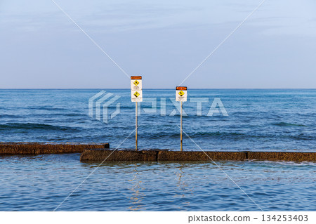 Blue sea and two warning signs on the horizon 134253403