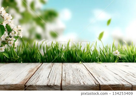 Spring background with fresh grass and white wooden table. Spring apple garden on the background Spring background with fresh grass and white wooden table. Spring apple garden on the background 134253409