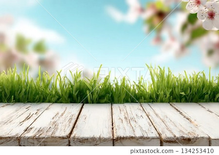Spring background with fresh grass and white wooden table. Spring apple garden on the background 134253410