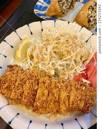 Crispy tonkatsu, a Japanese-style breaded and deep-fried pork cutlet, served with shredded cabbage and drizzled with savory sauce. A delightful balance of crunchy texture and juicy meat. Crispy tonkatsu, a Japanese-style breaded and deep-fried pork cutlet, served with shredded cabbage and drizzled with savory sauce. A delightful balance of crunchy texture and juicy meat. 134253842