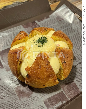 Korean garlic bread, a soft bun filled with creamy garlic butter and cream cheese, baked to golden perfection. A savory and slightly sweet treat with a rich, aromatic flavor. 134255148