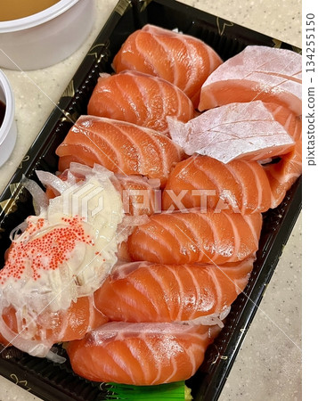 Fresh salmon sushi with bright orange slices placed on top of perfectly shaped rice, garnished with green leaves and radish for a simple, colorful, and appetizing presentation Fresh salmon sushi with bright orange slices placed on top of perfectly shaped rice, garnished with green leaves and radish for a simple, colorful, and appetizing presentation 134255150