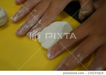 Children's hands kneading clay - craft time to develop creativity Children's hands kneading clay - craft time to develop creativity 134255824