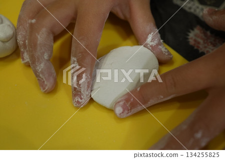 Children's hands kneading clay - craft time to develop creativity Children's hands kneading clay - craft time to develop creativity 134255825
