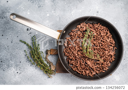 Frying Pan with fried mince beef meat, fresh cooked forcemeat. grey background. top view 134256072