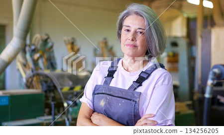 Senior woman worker crossing arms in factory workshop 134256205