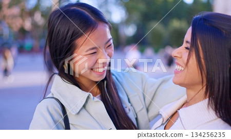 Diverse women friends smiling, embracing outdoors, showing inclusion Diverse women friends smiling, embracing outdoors, showing inclusion 134256235