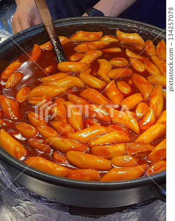 Spicy Korean tteokbokki with chewy rice cakes in a vibrant red sauce, topped with sesame seeds and green onions. A popular street food known for its addictive flavor and satisfying texture. Spicy Korean tteokbokki with chewy rice cakes in a vibrant red sauce, topped with sesame seeds and green onions. A popular street food known for its addictive flavor and satisfying texture. 134257078
