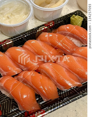 Fresh salmon sushi with bright orange slices placed on top of perfectly shaped rice, garnished with green leaves and radish for a simple, colorful, and appetizing presentation Fresh salmon sushi with bright orange slices placed on top of perfectly shaped rice, garnished with green leaves and radish for a simple, colorful, and appetizing presentation 134257093