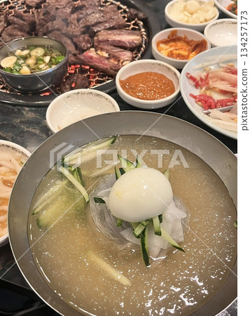 Authentic Pyongyang naengmyeon with chewy buckwheat noodles in cold, clear broth, offering a refreshing and delicate flavor. Perfect for traditional Korean cuisine menus and summer dishes. 134257173
