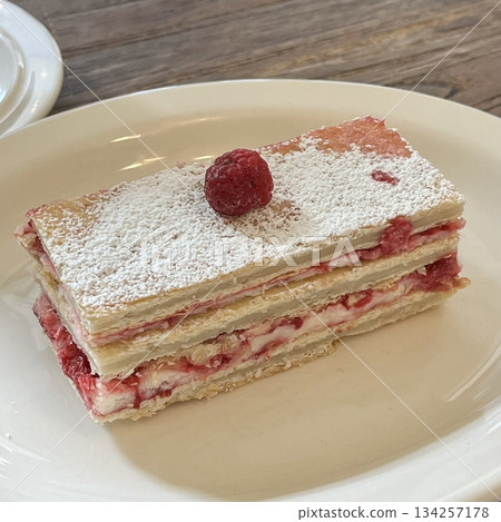 A delectable slice of cake with rich layers of cream and frosting, topped with fresh fruit or sprinkles. Perfect for dessert photography, showcasing indulgence and sweetness in food-related projects. 134257178
