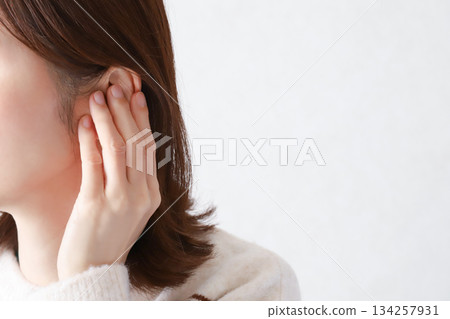 Woman experiencing discomfort in ear - ENT clinic Woman experiencing discomfort in ear - ENT clinic 134257931