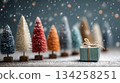 Miniature Christmas trees and gifts in snowy festive scene 134258251